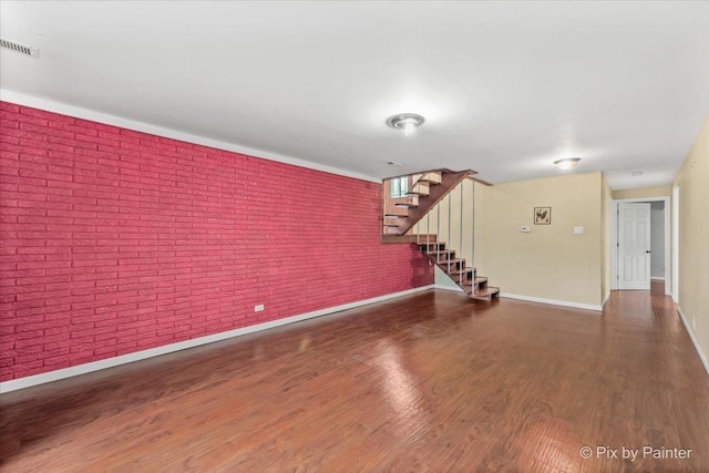 611 Brewster Ln, Schaumburg, IL 60193 - unfurnished living room featuring brick wall, stairway, baseboards, and wood finished floors