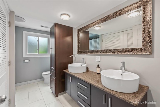 611 Brewster Ln, Schaumburg, IL 60193 - full bath featuring double vanity, toilet, baseboards, tile patterned flooring, and a closet
