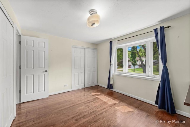 611 Brewster Ln, Schaumburg, IL 60193 - unfurnished bedroom featuring wood finished floors, baseboards, and a closet