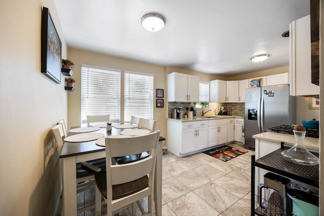1546 N Lee Blvd, Berkeley, IL 60163 - kitchen with backsplash, stainless steel fridge, white cabinets, light countertops, and a sink