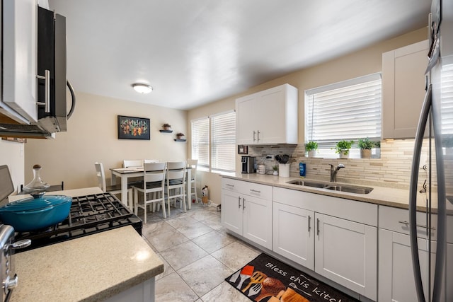 1546 N Lee Blvd, Berkeley, IL 60163 - kitchen featuring a sink, decorative backsplash, white cabinetry, freestanding refrigerator, and light tile patterned floors