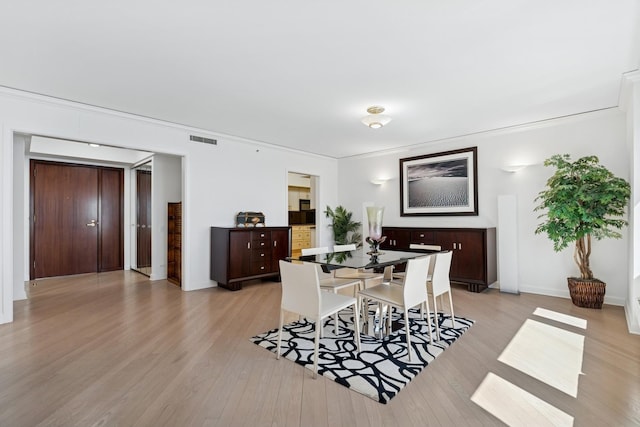 132 E Delaware Pl Unit 5504, Chicago, IL 60611 - dining space with light wood finished floors, crown molding, and baseboards