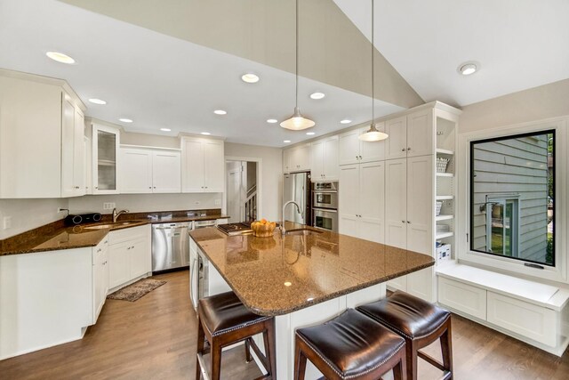 5S640 Bluff Ln, Naperville, IL 60540 - kitchen with appliances with stainless steel finishes, dark wood finished floors, a breakfast bar, glass insert cabinets, and dark stone countertops