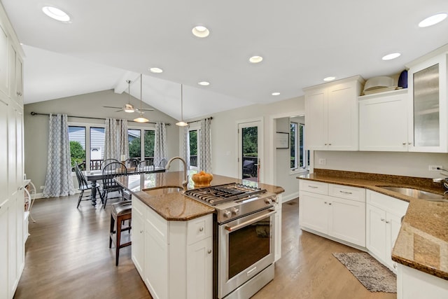 5S640 Bluff Ln, Naperville, IL 60540 - kitchen with gas range, a sink, light wood-style flooring, dark stone counters, and vaulted ceiling