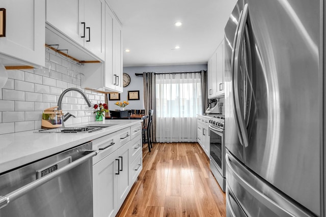 86611/2 W Foster Ave Unit 3A, Chicago, IL 60656 - kitchen featuring stainless steel appliances, a sink, light wood-style flooring, light countertops, and white cabinetry
