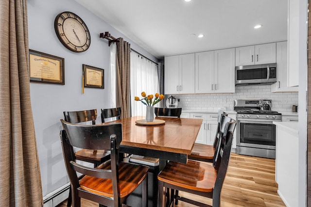 86611/2 W Foster Ave Unit 3A, Chicago, IL 60656 - dining area with light wood-style floors, recessed lighting, and a baseboard radiator