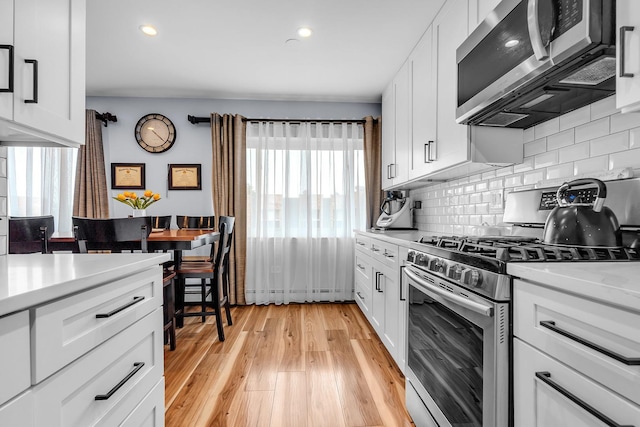 86611/2 W Foster Ave Unit 3A, Chicago, IL 60656 - kitchen featuring stainless steel appliances, light countertops, decorative backsplash, light wood finished floors, and recessed lighting