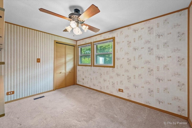 1434 Somerset Ln, Schaumburg, IL 60193 - unfurnished bedroom with ornamental molding, carpet, a closet, wallpapered walls, and ceiling fan