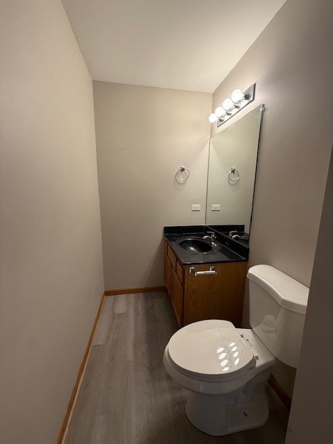 916 Bluegrass Ln, Plano, IL 60545 - bathroom featuring toilet, wood finished floors, vanity, and baseboards
