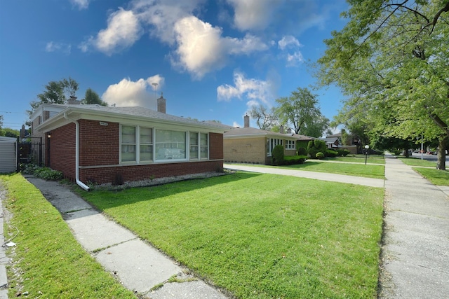 10945 S Lowe Ave, Chicago, IL 60628 - view of front facade with brick siding, a chimney, and a front yard