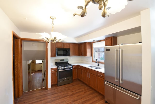 10945 S Lowe Ave, Chicago, IL 60628 - kitchen with stainless steel appliances, a sink, a chandelier, light countertops, and dark wood finished floors