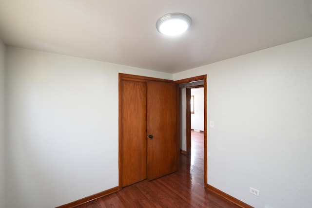 10945 S Lowe Ave, Chicago, IL 60628 - unfurnished bedroom with baseboards, dark wood-style floors, and a closet