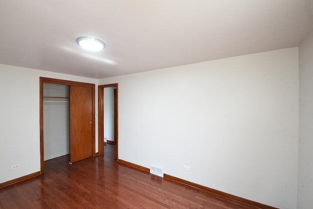 10945 S Lowe Ave, Chicago, IL 60628 - unfurnished bedroom featuring dark wood-style flooring, baseboards, and a closet