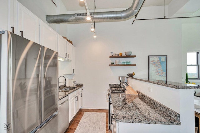 1645 W Ogden Ave Unit 722, Chicago, IL 60612 - kitchen featuring appliances with stainless steel finishes, dark wood finished floors, a sink, dark stone countertops, and white cabinets