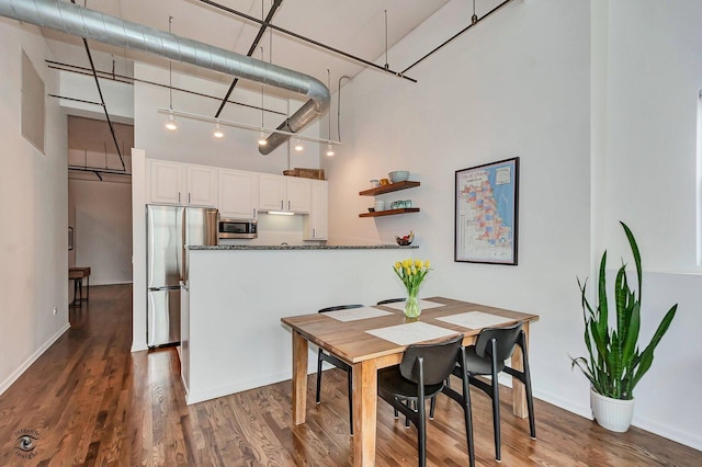 1645 W Ogden Ave Unit 722, Chicago, IL 60612 - dining area featuring a high ceiling, dark wood-style floors, and baseboards