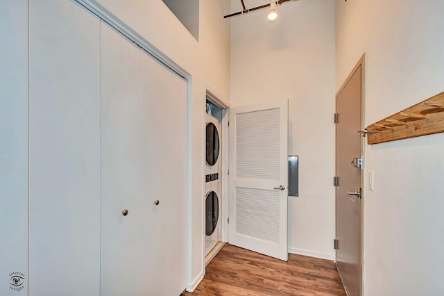 1645 W Ogden Ave Unit 722, Chicago, IL 60612 - laundry area featuring estacked washer and dryer, light wood-style floors, baseboards, and a high ceiling