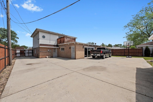 6315 W 83rd Pl, Burbank, IL 60459 - rear view of property featuring brick siding, a balcony, a gate, and concrete driveway