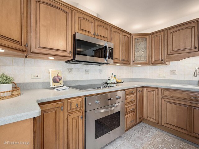 941 Meadowcrest Rd, La Grange Park, IL 60526 - kitchen featuring stainless steel appliances, brown cabinets, a sink, and light countertops