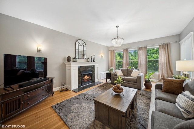 1055 E Hyde Park Blvd Unit 3, Chicago, IL 60615 - living room featuring light wood-style floors, a chandelier, a high end fireplace, and baseboards