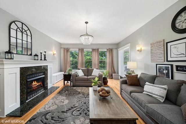 1055 E Hyde Park Blvd Unit 3, Chicago, IL 60615 - living area featuring wood finished floors, a chandelier, and a premium fireplace