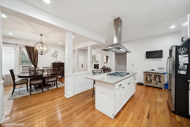 1055 E Hyde Park Blvd Unit 3, Chicago, IL 60615 - kitchen featuring island range hood, appliances with stainless steel finishes, white cabinets, light wood-style flooring, and a kitchen island