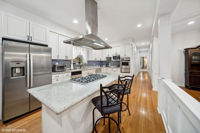 1055 E Hyde Park Blvd Unit 3, Chicago, IL 60615 - kitchen with appliances with stainless steel finishes, island exhaust hood, white cabinets, decorative backsplash, and a warming drawer