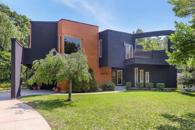 16W307 95th Pl, Burr Ridge, IL 60527 - modern home with a balcony, a front yard, and board and batten siding