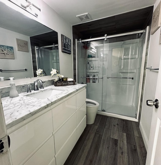 1330 Todd Farm Dr, Elgin, IL 60123 - bathroom featuring wood finished floors, vanity, a shower stall, and toilet