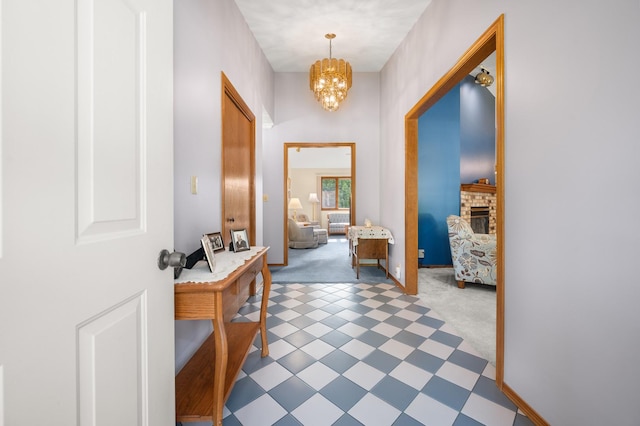 10 Primrose Ln, Sycamore, IL 60178 - foyer entrance with light carpet, a chandelier, a fireplace, and baseboards