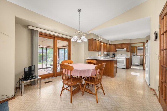 10 Primrose Ln, Sycamore, IL 60178 - dining space with vaulted ceiling, a chandelier, washer / dryer, and light flooring
