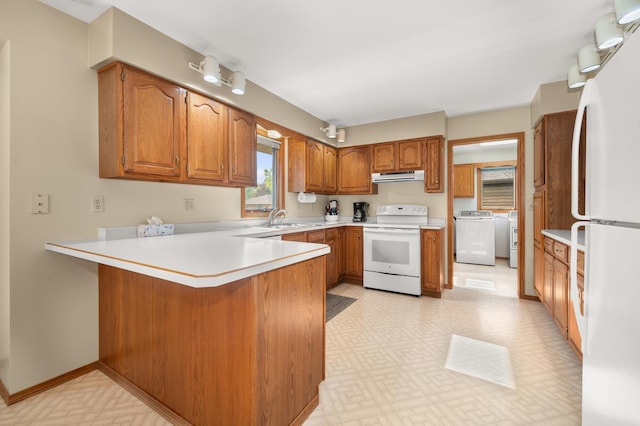 10 Primrose Ln, Sycamore, IL 60178 - kitchen with white appliances, under cabinet range hood, a peninsula, separate washer and dryer, and brown cabinets