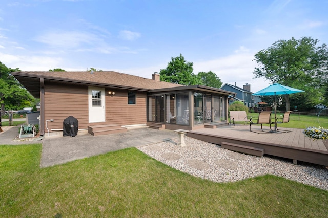 10 Primrose Ln, Sycamore, IL 60178 - rear view of house featuring a sunroom, a deck, a yard, a chimney, and a patio