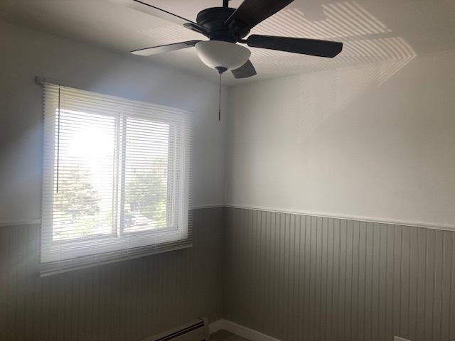 129 Elk Trl W Unit 329, Carol Stream, IL 60188 - spare room featuring a wainscoted wall, ceiling fan, and a baseboard radiator
