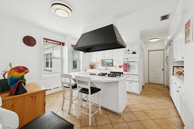 5555 N Sheridan Rd Unit 1906, Chicago, IL 60640 - kitchen with extractor fan, white oven, a warming drawer, white cabinets, and a center island