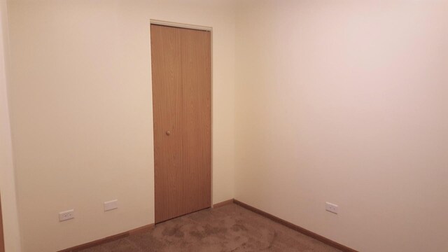 1341 Cunat Ct Unit 1C, Lake In The Hills, IL 60156 - spare room featuring carpet floors and baseboards