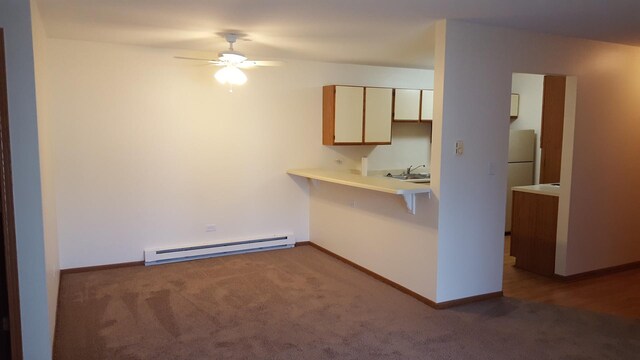 1341 Cunat Ct Unit 1C, Lake In The Hills, IL 60156 - kitchen with a baseboard heating unit, carpet floors, a ceiling fan, light countertops, and a sink