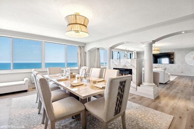 1440 N Lake Shore Dr Unit 34Ac, Chicago, IL 60610 - dining area featuring decorative columns, light wood-type flooring, a fireplace, crown molding, and a water view