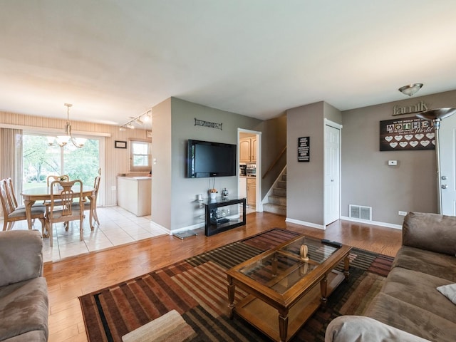 521 Harvard Ln, Hoffman Estates, IL 60169 - living room with light wood-style floors, stairway, baseboards, and a chandelier