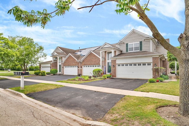 117 Andrew Taras Ct Unit B1, Joliet, IL 60435 - view of front of house featuring brick siding, asphalt driveway, a garage, and solar panels
