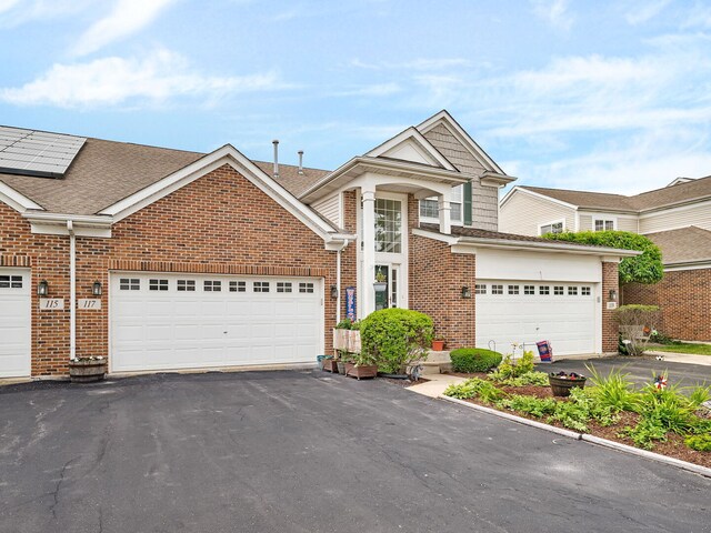 117 Andrew Taras Ct Unit B1, Joliet, IL 60435 - traditional-style house with brick siding, asphalt driveway, a shingled roof, and an attached garage