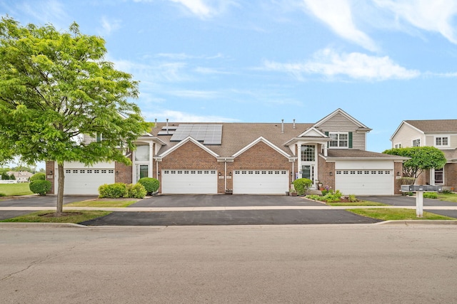 117 Andrew Taras Ct Unit B1, Joliet, IL 60435 - view of property featuring brick siding, solar panels, and driveway