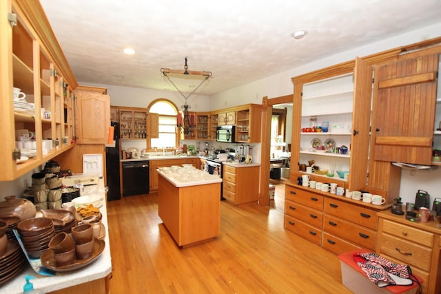 5250 Harvey Rd, Caledonia, IL 61011 - kitchen featuring black appliances, open shelves, a center island, light countertops, and light wood-style floors
