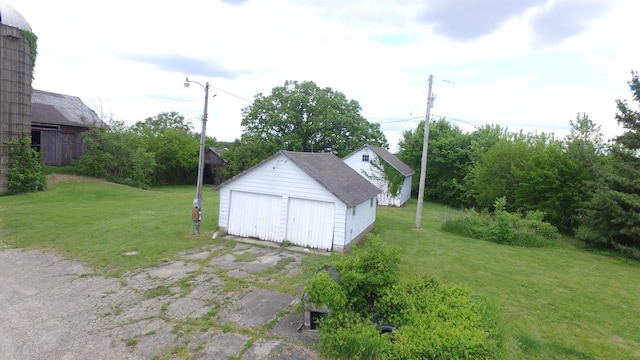 5250 Harvey Rd, Caledonia, IL 61011 - view of green lawn featuring a detached garage and an outdoor structure