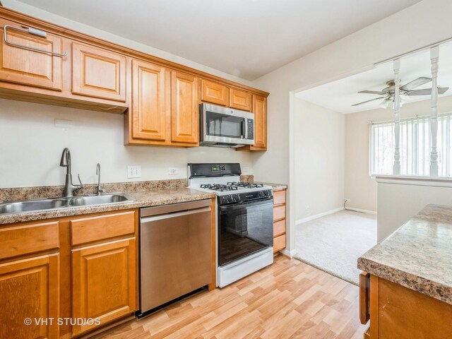 127 Wolcott Ct Unit 2, Schaumburg, IL 60193 - kitchen with stainless steel appliances, a sink, light wood-type flooring, ceiling fan, and baseboards