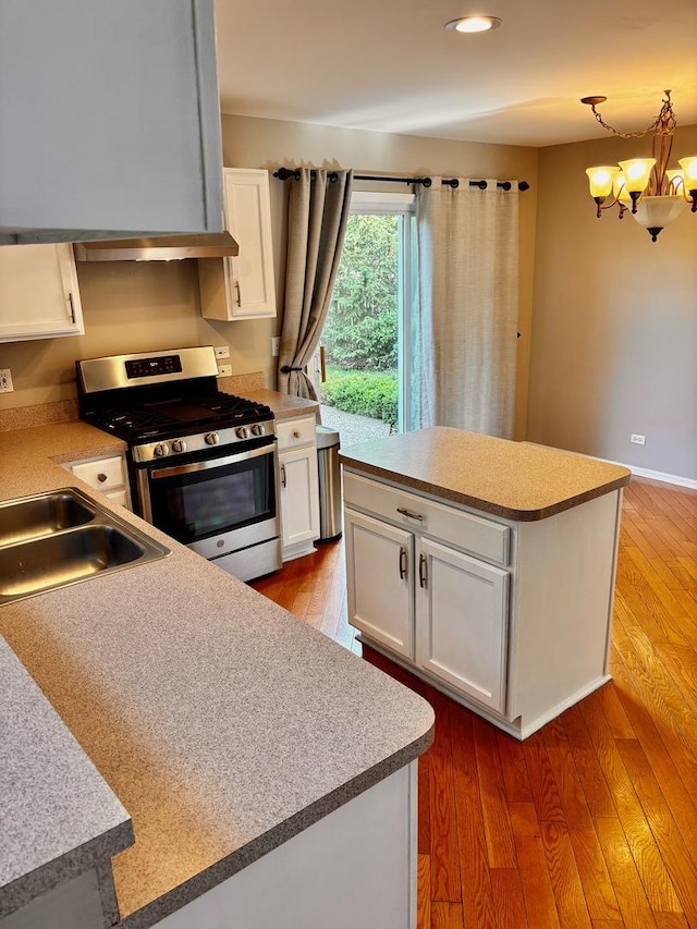 34165 N Goldenrod Rd, Round Lake, IL 60073 - kitchen with stainless steel range with gas stovetop, a chandelier, white cabinetry, a kitchen island, and recessed lighting