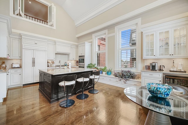 201 Reber St Unit 6, Wheaton, IL 60187 - kitchen featuring high vaulted ceiling, white cabinetry, tasteful backsplash, glass insert cabinets, and light stone counters