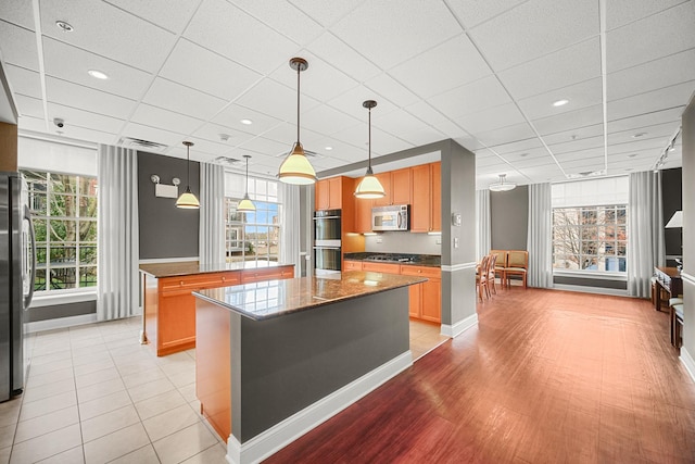 201 Reber St Unit 6, Wheaton, IL 60187 - kitchen with appliances with stainless steel finishes, a center island, healthy amount of natural light, a drop ceiling, and pendant lighting