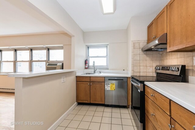 4960 N Marine Dr Unit 720, Chicago, IL 60640 - kitchen featuring stainless steel appliances, range hood, brown cabinets, and tasteful backsplash
