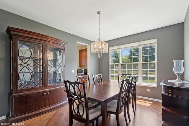 2621 Hastings Ct, Gurnee, IL 60031 - dining room with baseboards, a chandelier, and wood finished floors