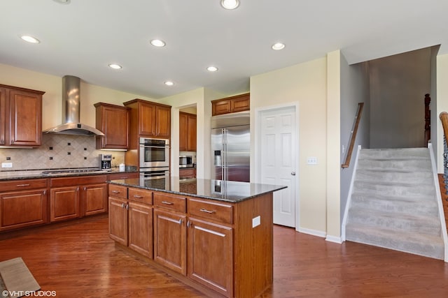 2621 Hastings Ct, Gurnee, IL 60031 - kitchen with wall chimney exhaust hood, stainless steel appliances, a kitchen island, dark wood-type flooring, and brown cabinetry